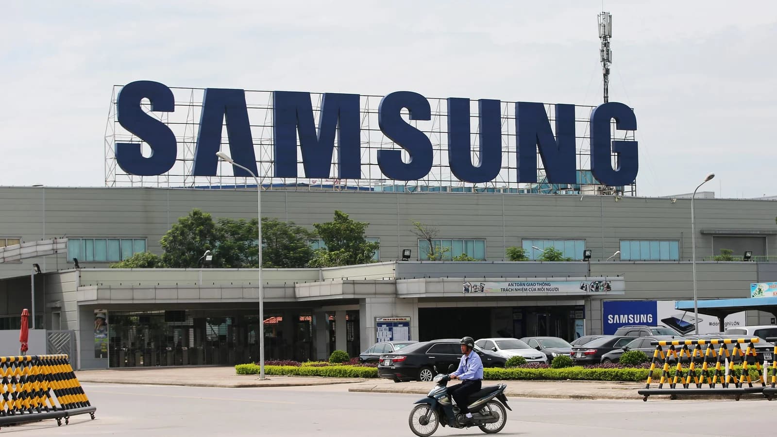 A motorcyclist rides past a large Samsung sign atop a Samsung Electronics factory in Bac Ninh province, Vietnam